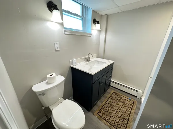 a bathroom with a sink toilet and window