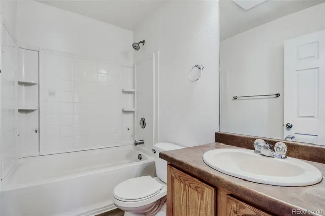 a bathroom with a toilet a sink a mirror a bathtub and shower