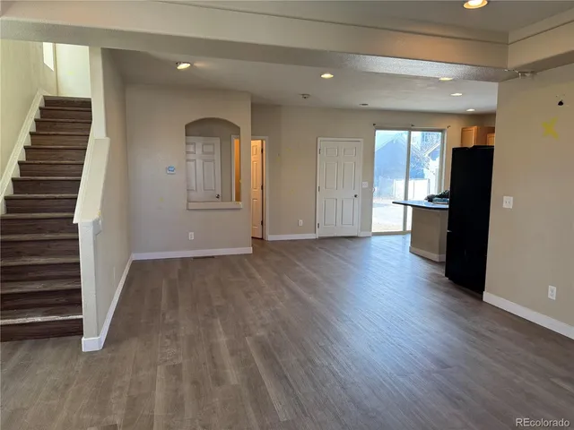 a view of a hallway with wooden floor and staircase