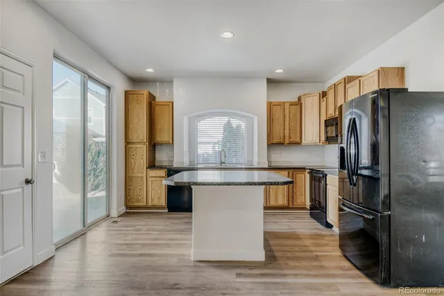 a kitchen with stainless steel appliances granite countertop a refrigerator a stove and a sink