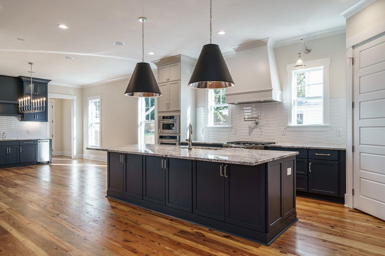 213 Georgetown Road Raleigh, NC 27608 - Photo 3 of 44 a kitchen with stainless steel appliances granite countertop wooden floors stove and sink