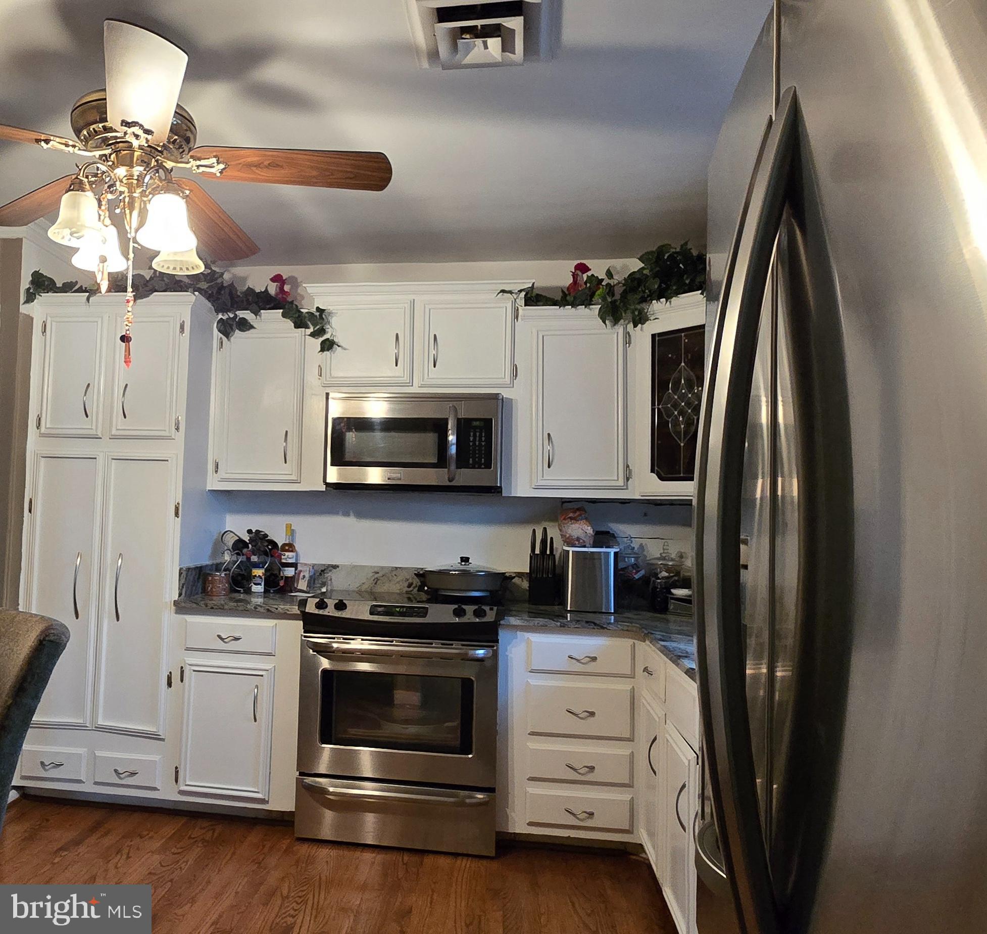 11507 Keystone Avenue Clinton, MD 20735 - Photo 9 of 33 a kitchen with stainless steel appliances a stove a refrigerator and cabinets