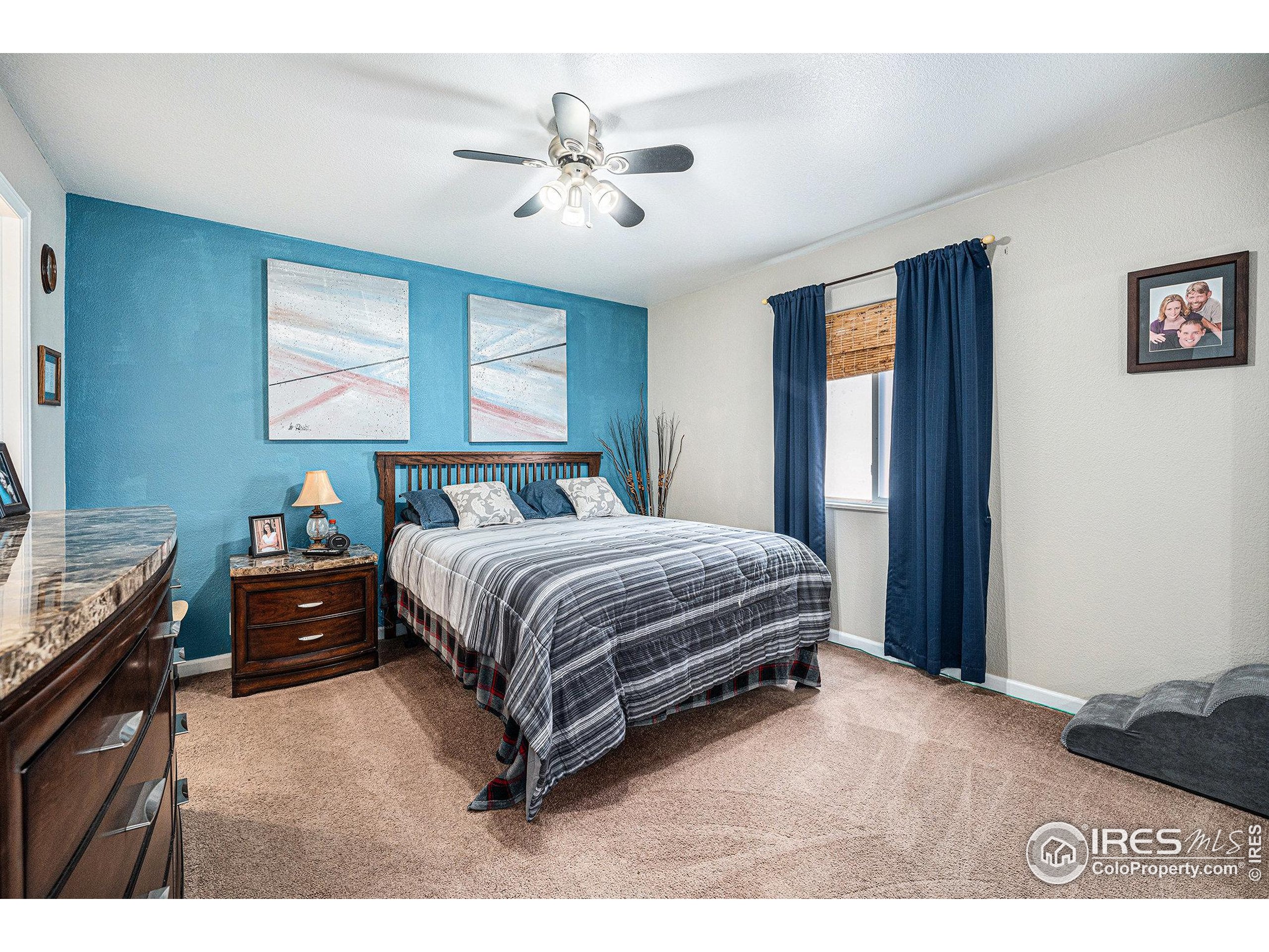 1030 South Fulton Avenue Fort Lupton, CO 80621 - Photo 9 of 26 a bedroom with a bed and a chandelier