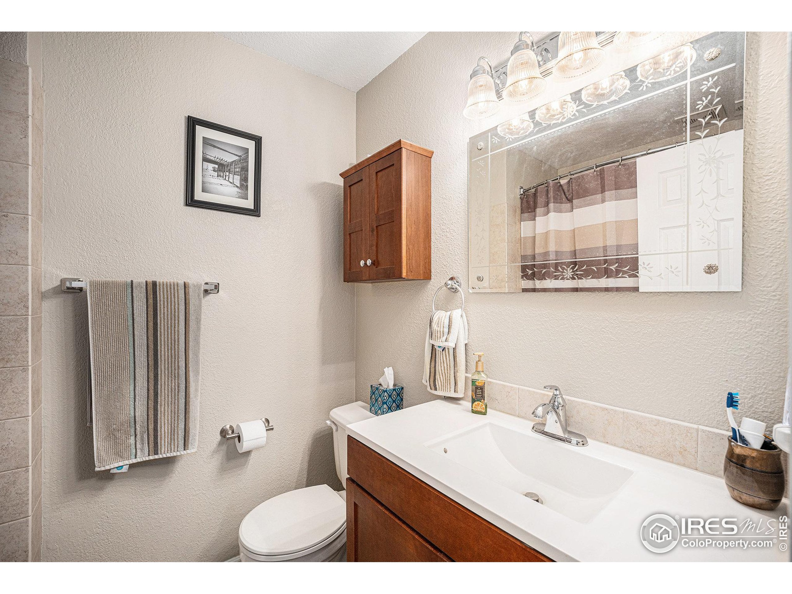 1030 South Fulton Avenue Fort Lupton, CO 80621 - Photo 10 of 26 a bathroom with a sink toilet and mirror