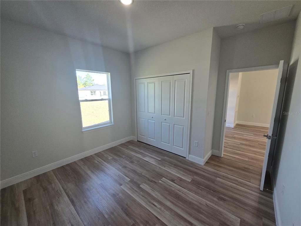 2644 Southwest 162nd Street Road Ocala, FL 34473 - Photo 30 of 47 a view of an empty room with wooden floor and a window