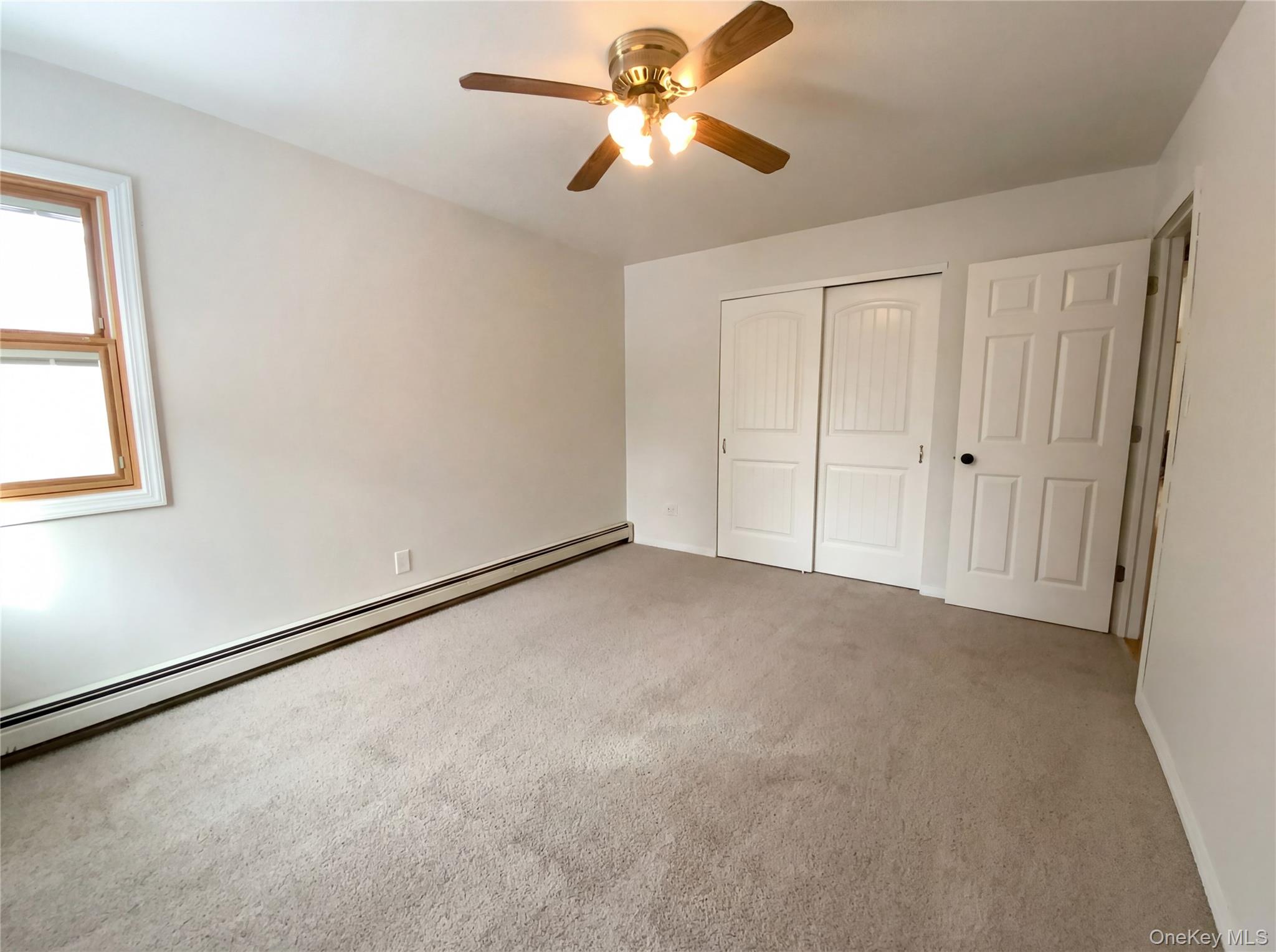 269 Prince Road Brookhaven, NY 11778 - Photo 4 of 22 a view of a room with a ceiling fan and a window