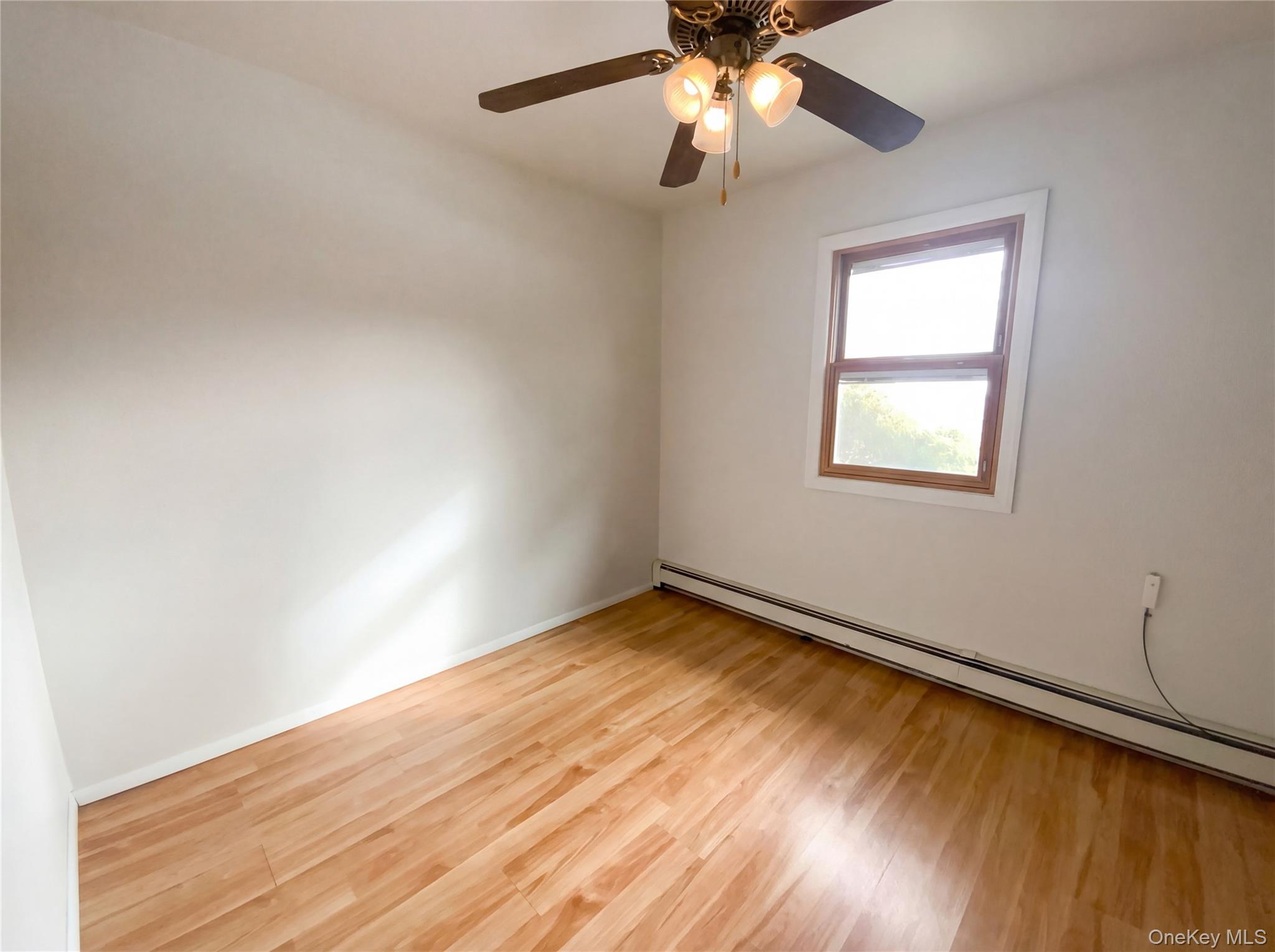 269 Prince Road Brookhaven, NY 11778 - Photo 9 of 22 wooden floor in an empty room with a window