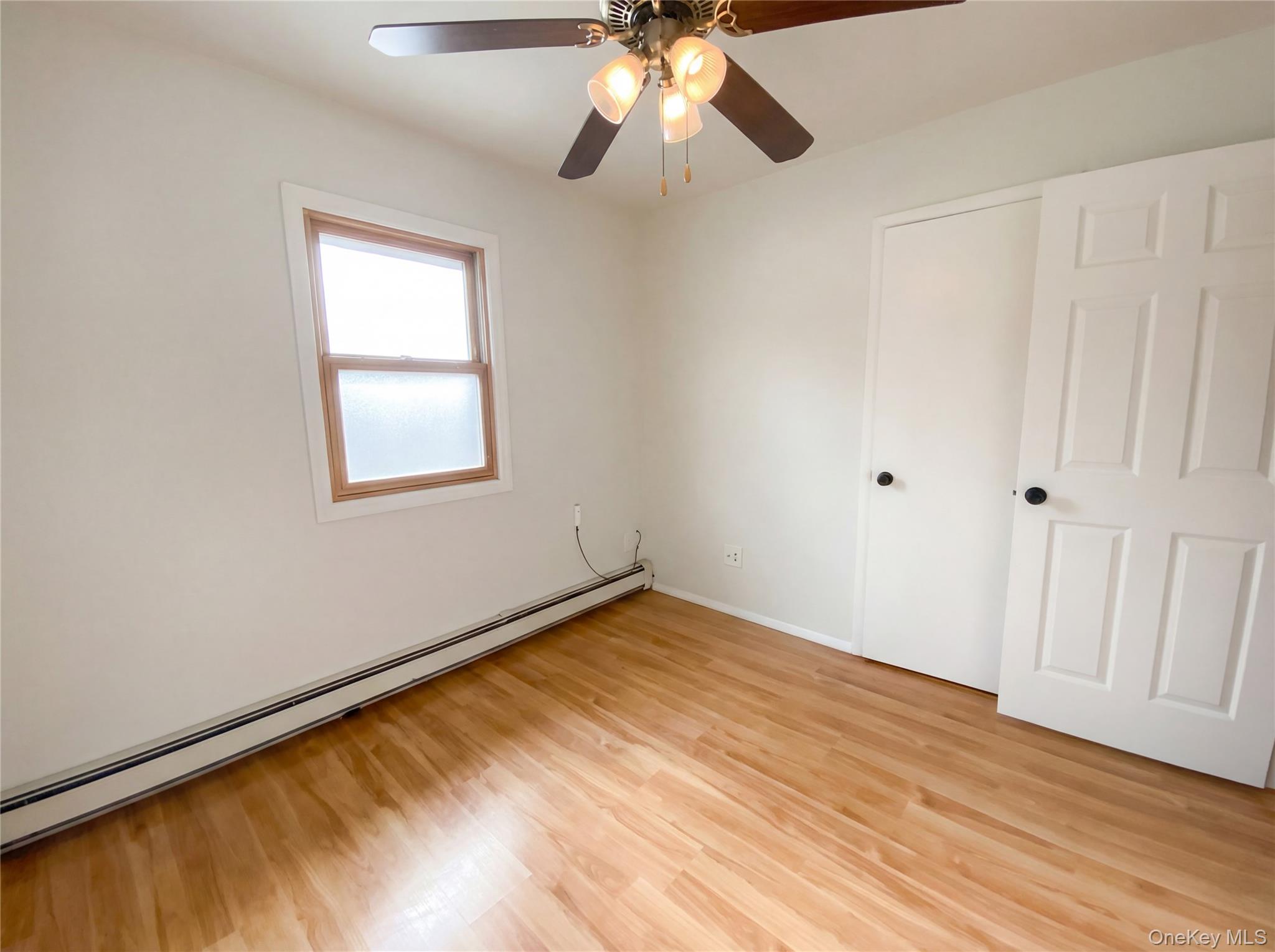 269 Prince Road Brookhaven, NY 11778 - Photo 10 of 22 wooden floor in an empty room with a window