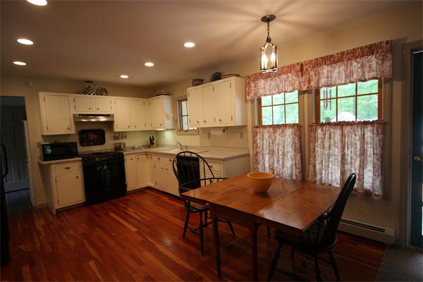 829 Division Road Westport, MA 02790 - Photo 7 of 15 a kitchen with a table chairs sink and cabinets