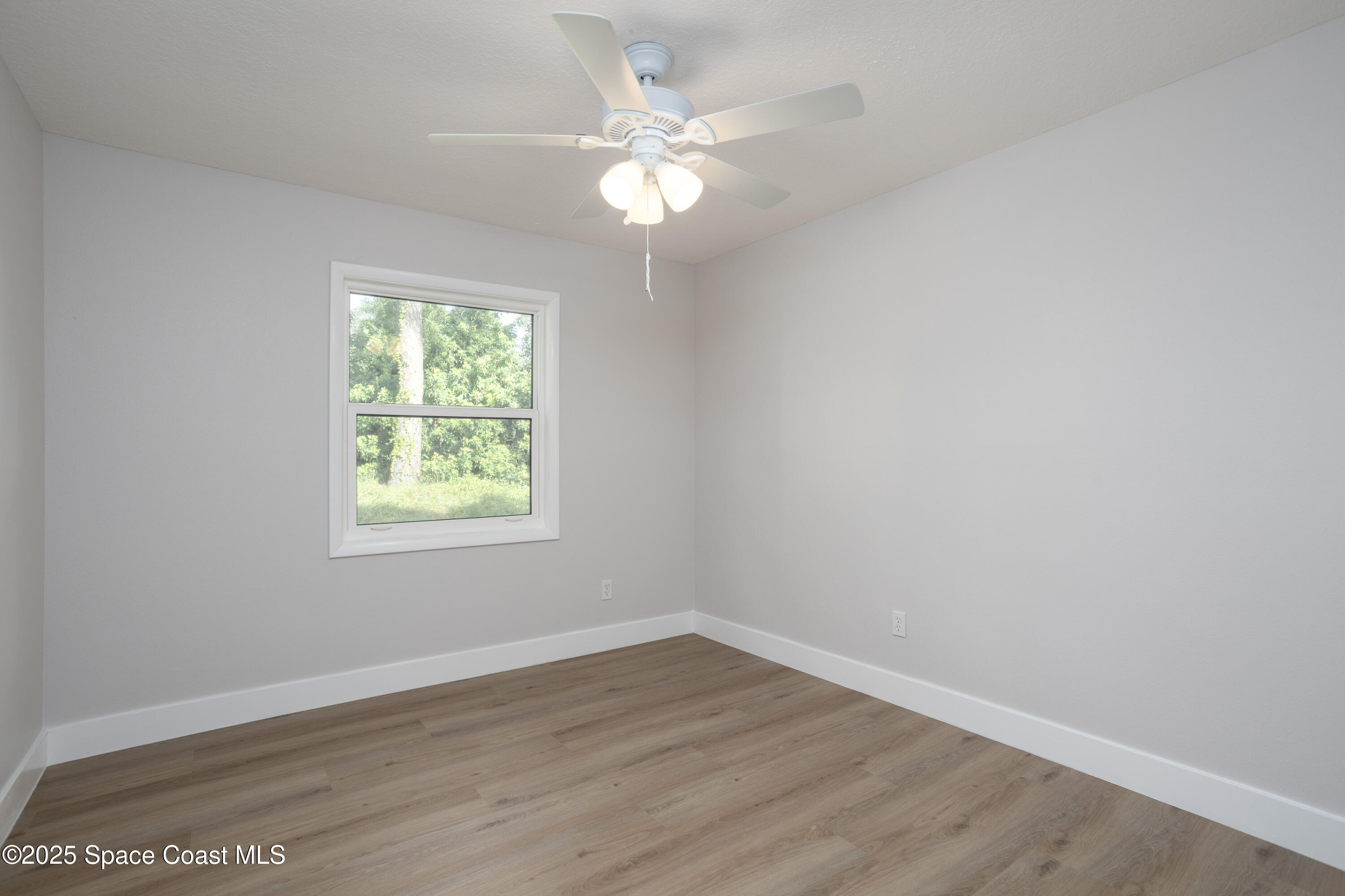 5446 Jamaica Road Cocoa, FL 32927 - Photo 16 of 21 an empty room with wooden floor and windows