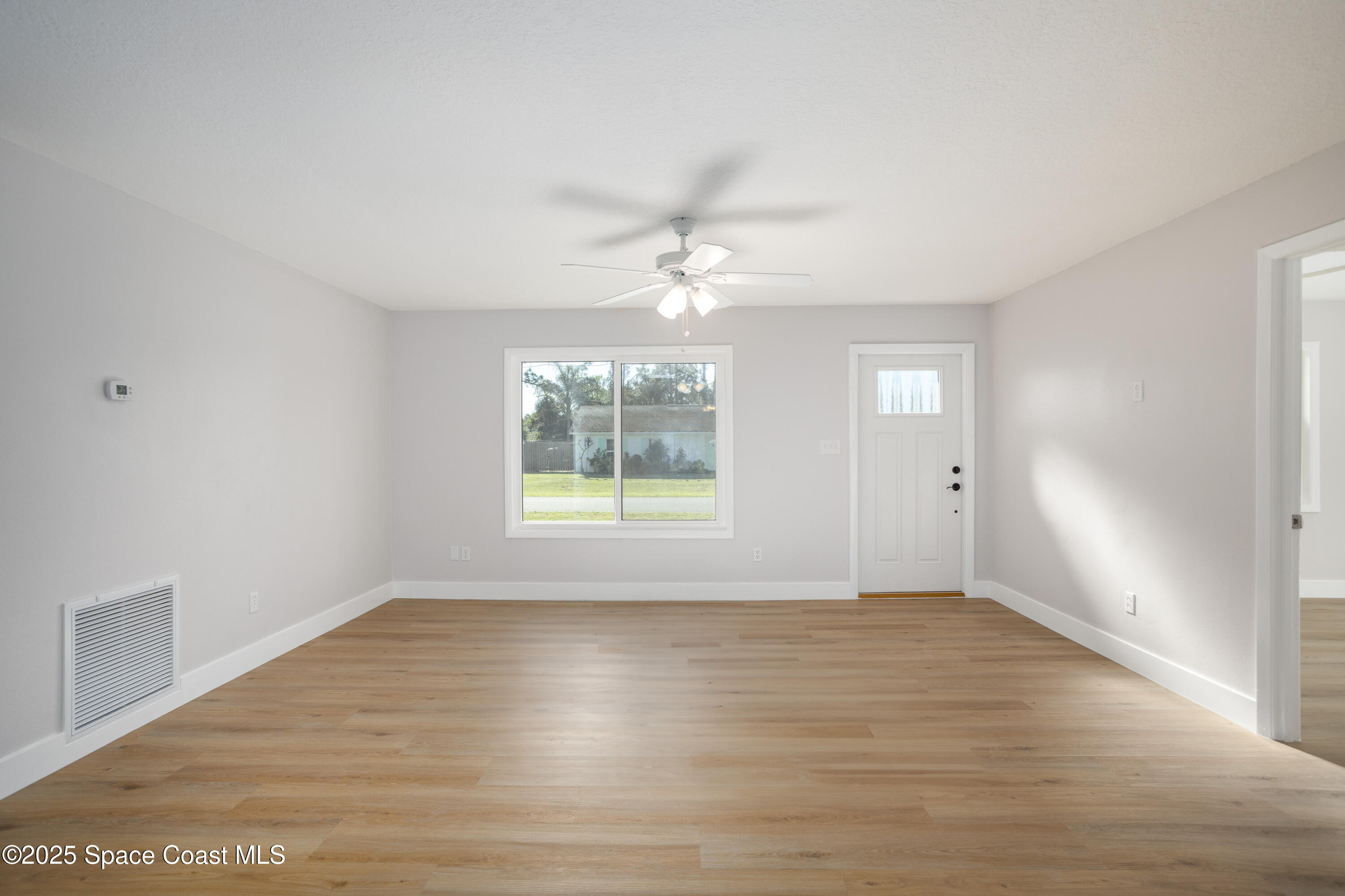 5446 Jamaica Road Cocoa, FL 32927 - Photo 5 of 21 wooden floor in an empty room with a window