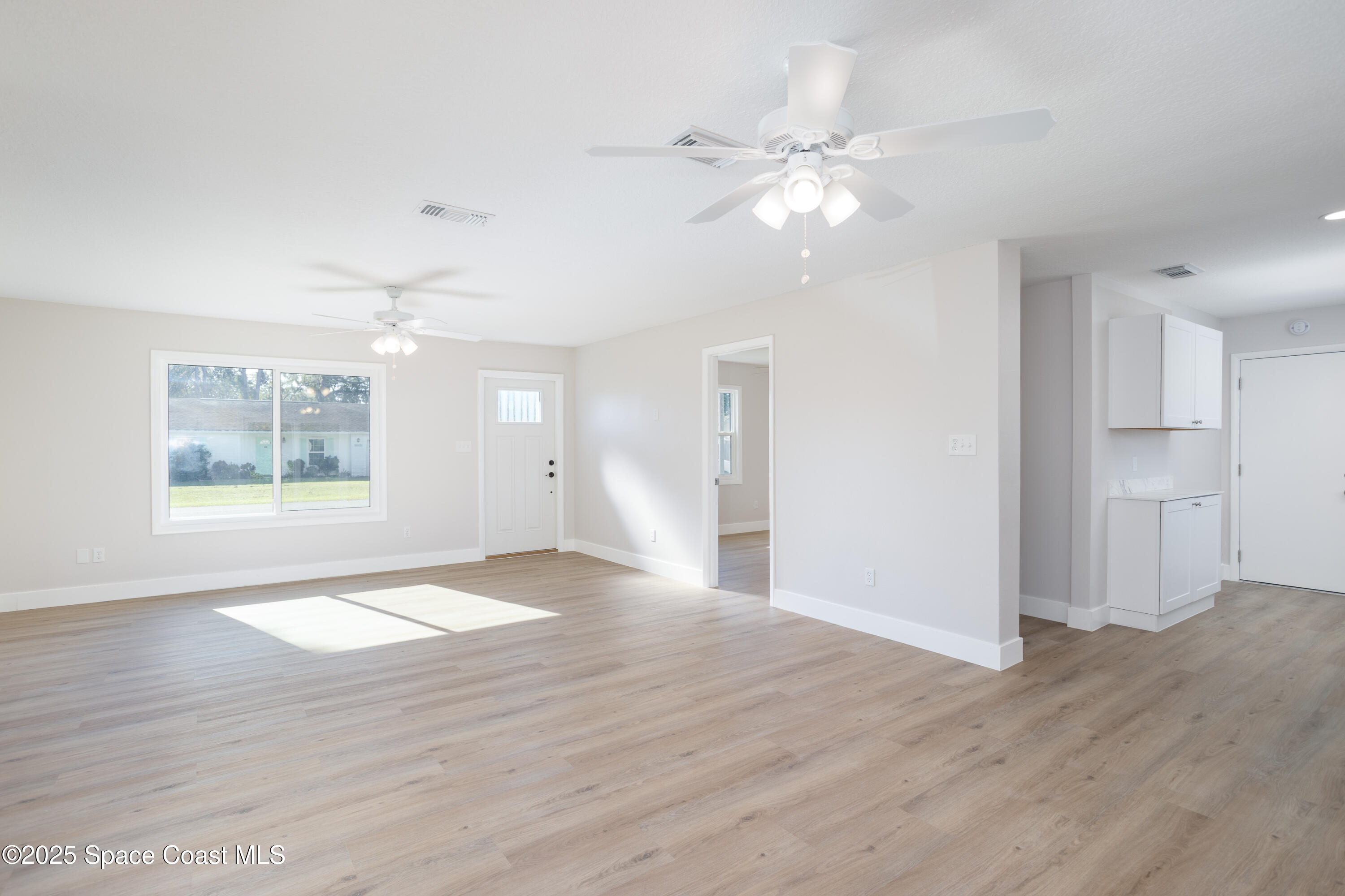 5446 Jamaica Road Cocoa, FL 32927 - Photo 6 of 21 a view of an empty room with wooden floor and a window
