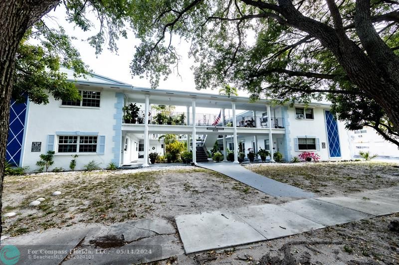 a front view of a house with a yard and potted plants