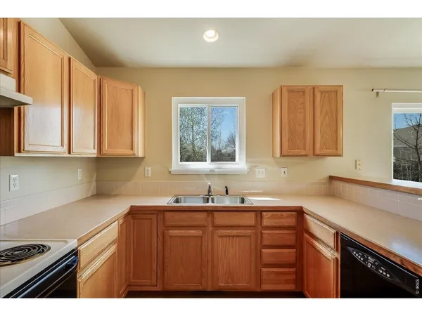 a kitchen with stainless steel appliances a sink a stove a microwave a refrigerator a counter top and cabinets