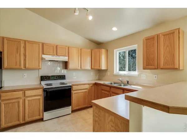 a kitchen with a stove a refrigerator and a sink