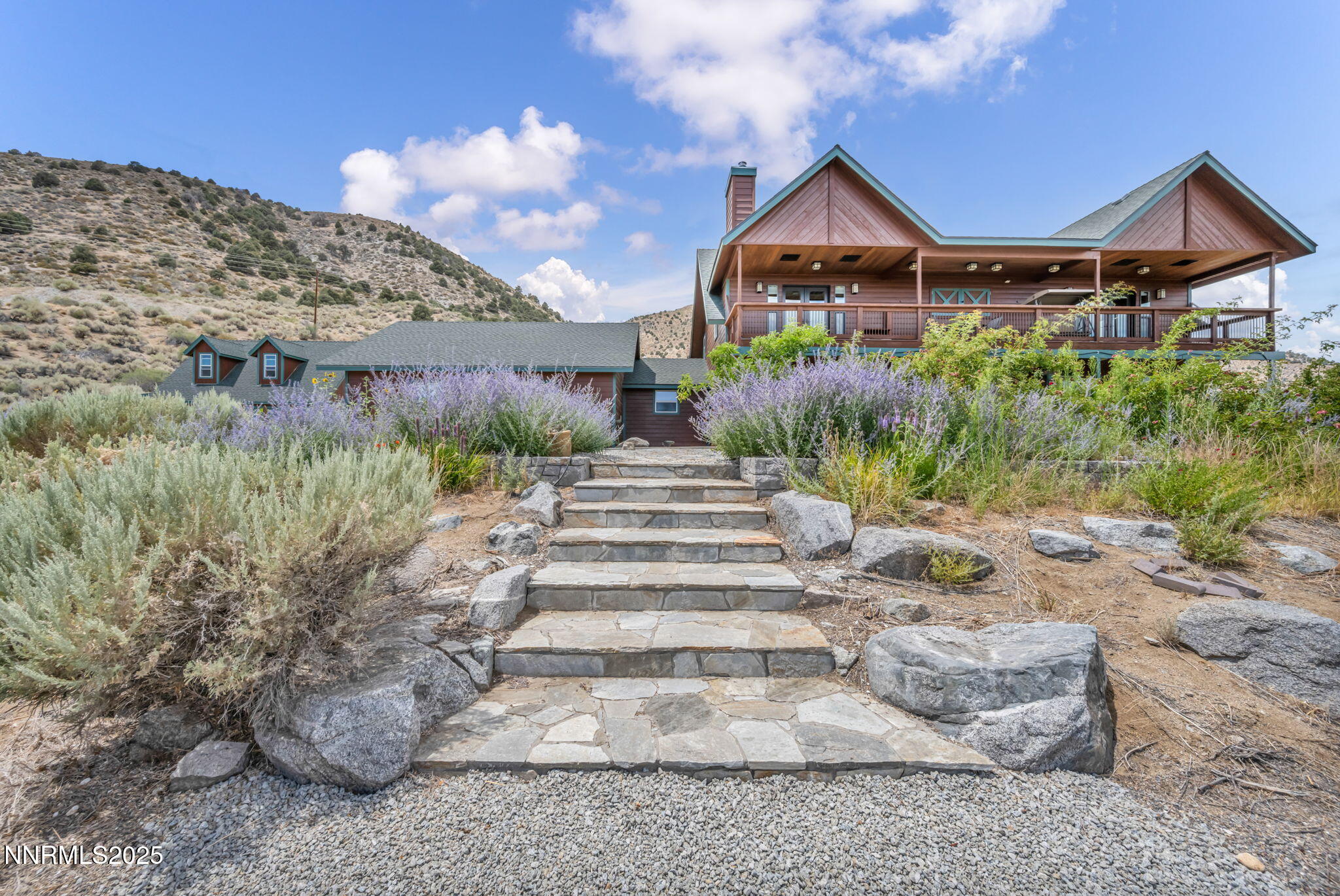 a front view of a house with a yard and potted plants