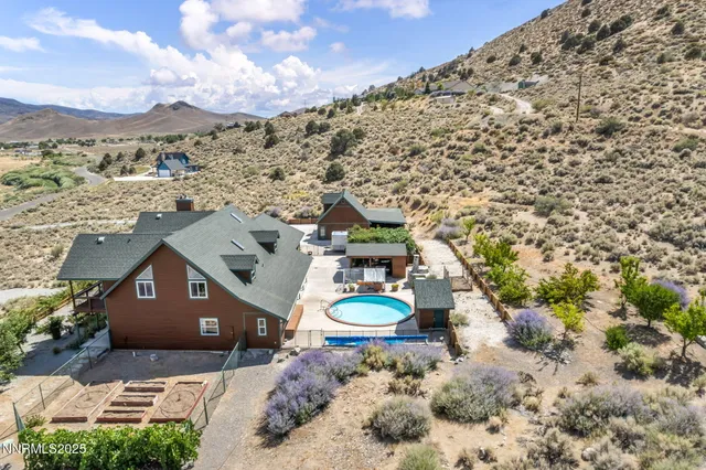 an aerial view of a house with a mountain