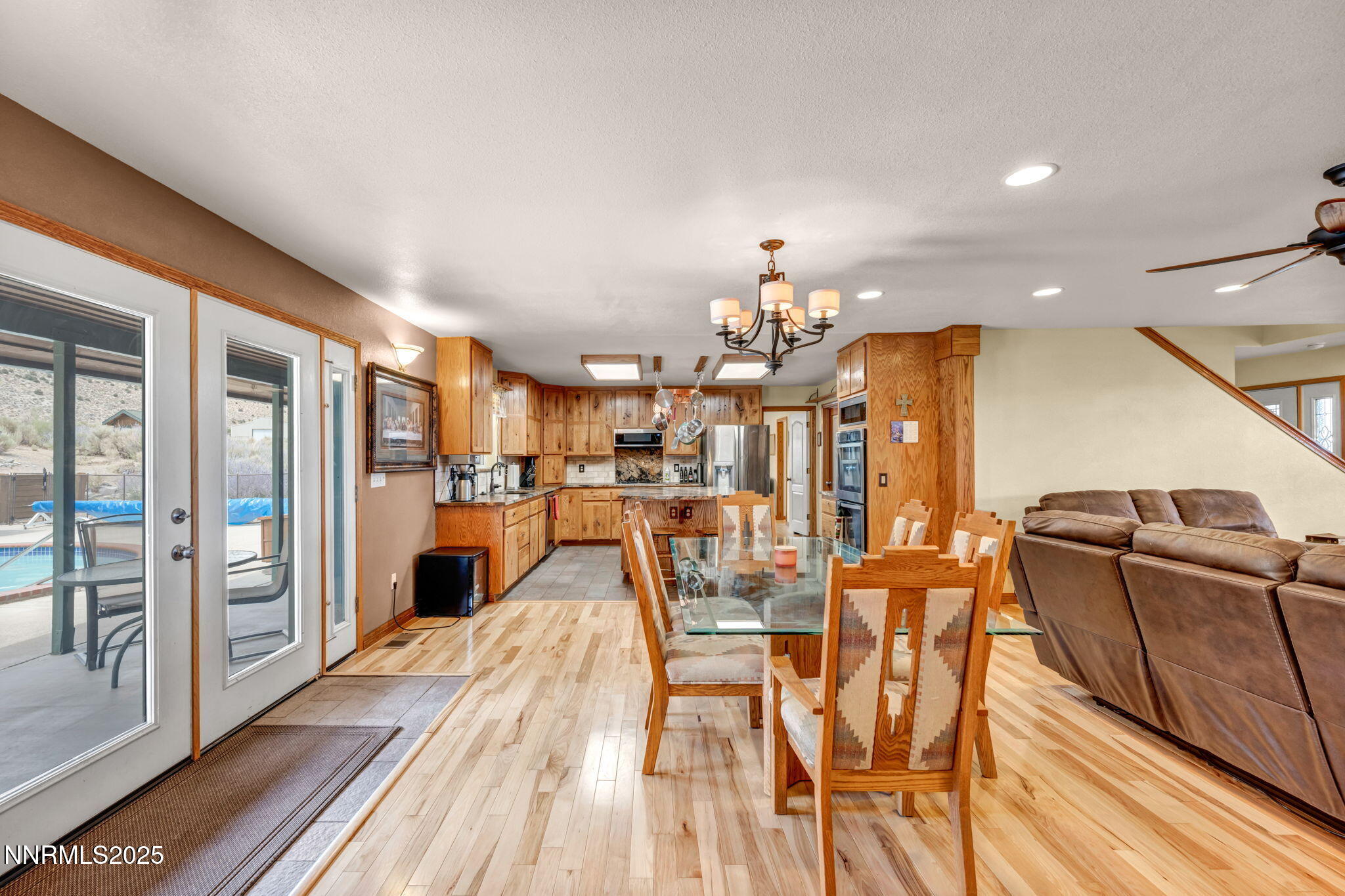 111 Upper Colony Road Wellington, NV 89444 - Photo 49 of 49 a open kitchen with stainless steel appliances kitchen island granite countertop a refrigerator a stove a dining table and chairs with wooden floor