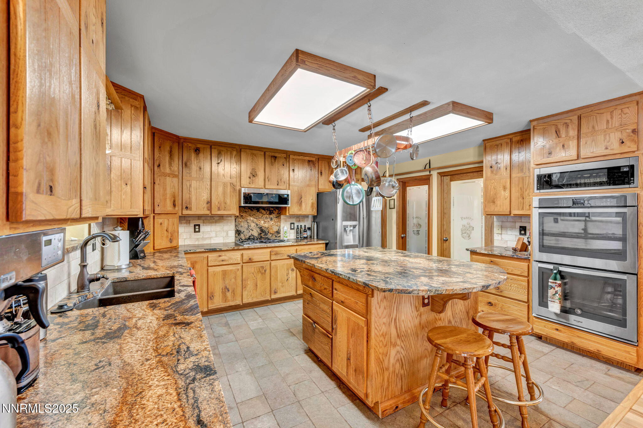 111 Upper Colony Road Wellington, NV 89444 - Photo 8 of 49 a kitchen with stainless steel appliances granite countertop a stove top oven a sink dishwasher a dining table and chairs with wooden floor