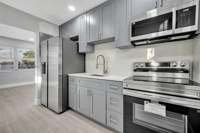 a kitchen with stainless steel appliances granite countertop a stove microwave and refrigerator