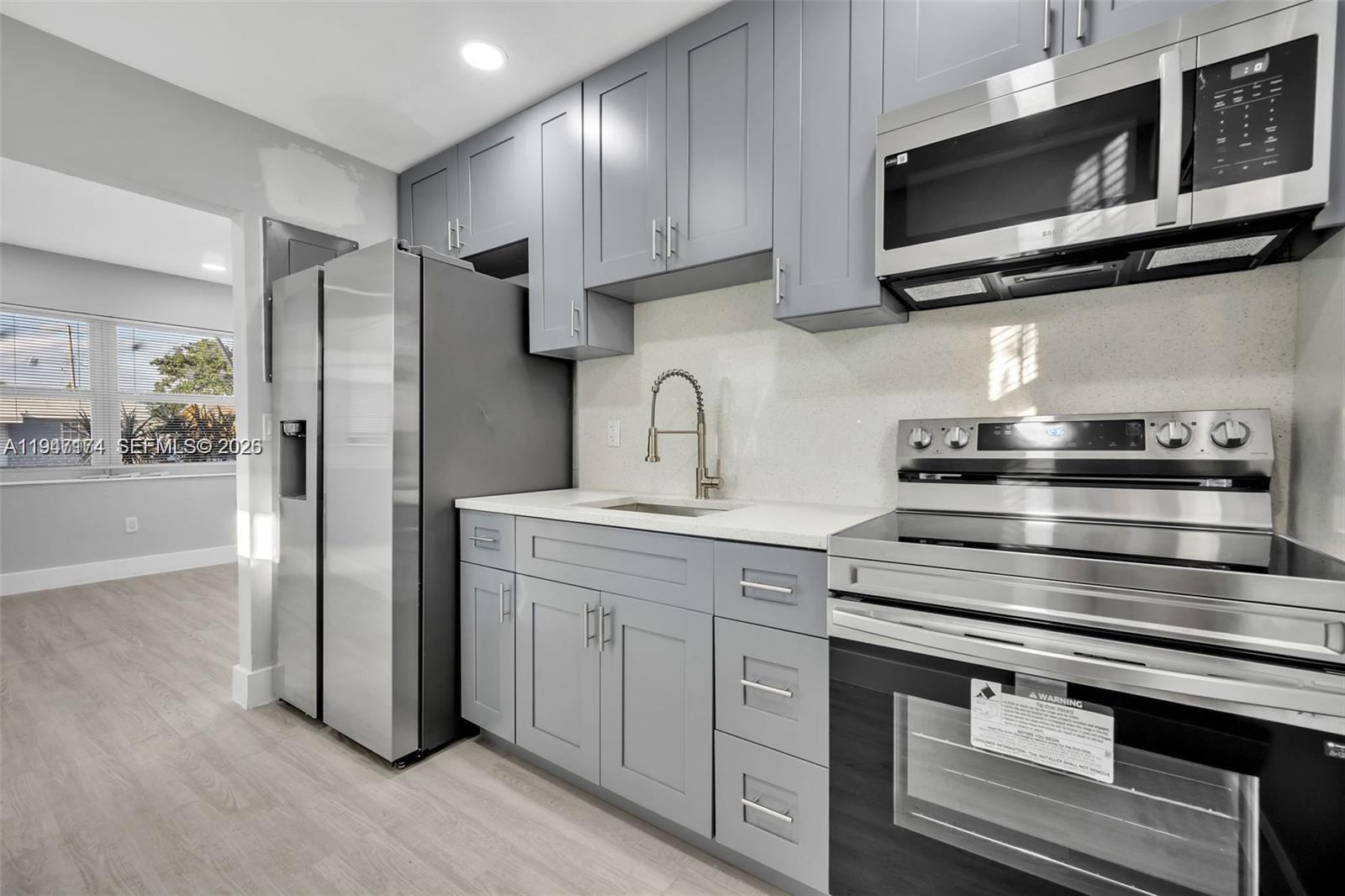 6326 Southwest 24th Street Miramar, FL 33023 - Photo 2 of 14 a kitchen with stainless steel appliances granite countertop a stove microwave and refrigerator
