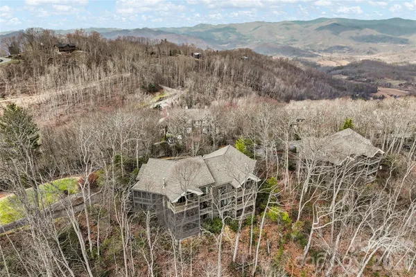 an aerial view of a house with a mountain