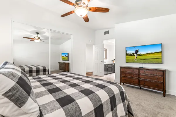 a bedroom with a bed chandelier and a closet