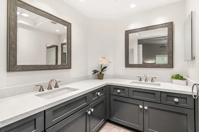 a bathroom with a sink a mirror a vanity and a shower