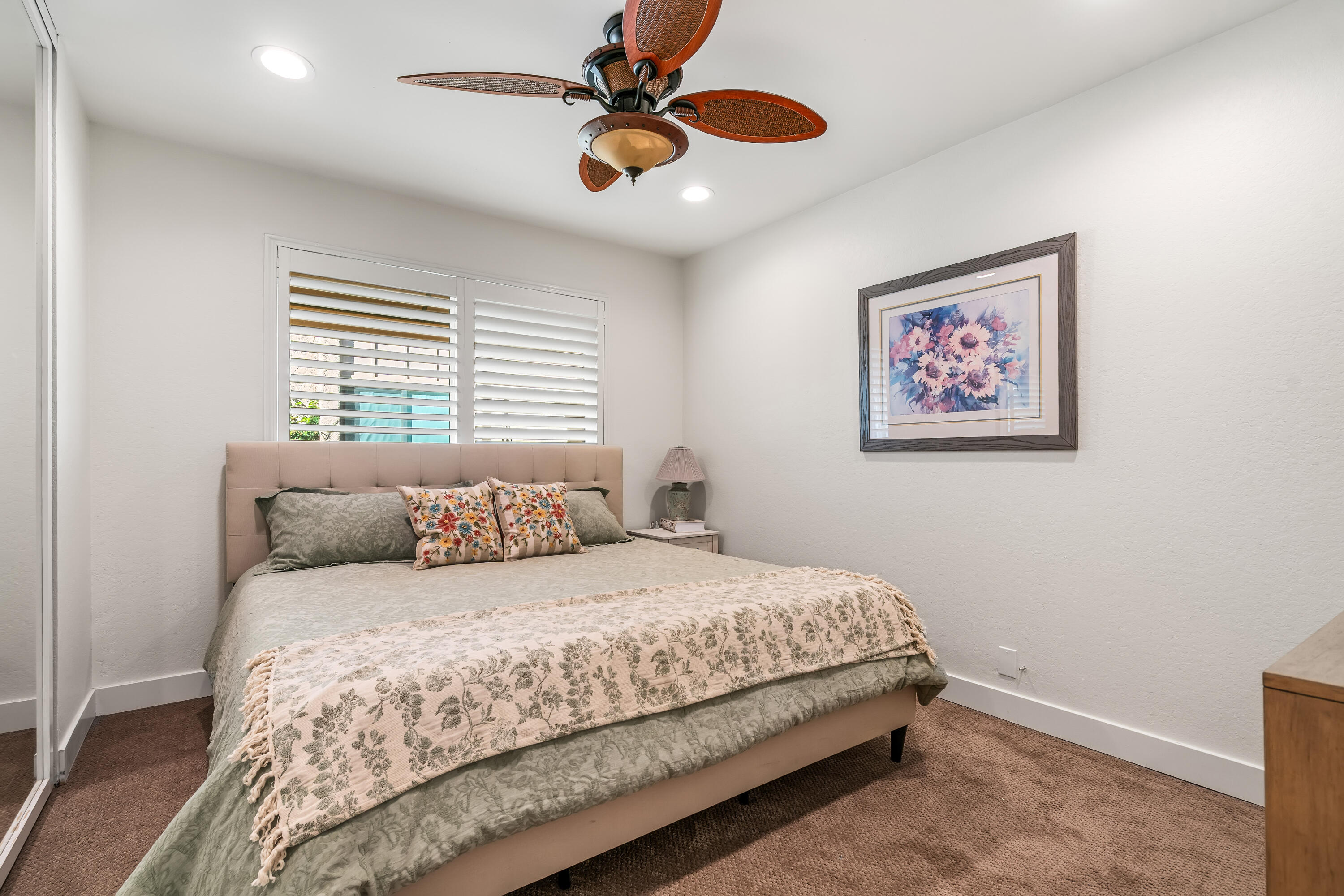 82 Conejo Circle Palm Desert, CA 92260 - Photo 21 of 58 a bedroom with a large bed and a ceiling fan