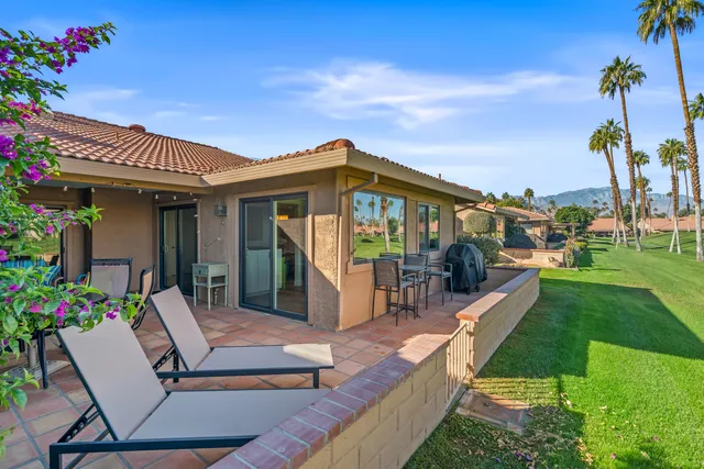 a view of a chairs and table in patio with a yard