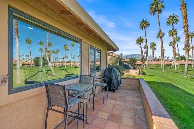 an aerial view of a tennis ground and a cars park side of the road