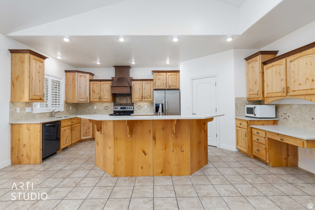 2327 Bluff Ridge Drive Syracuse, UT 84075 - Photo 14 of 66 Spacious kitchen featuring a central island, light wood cabinetry with dark crown molding, tile flooring, and light countertops