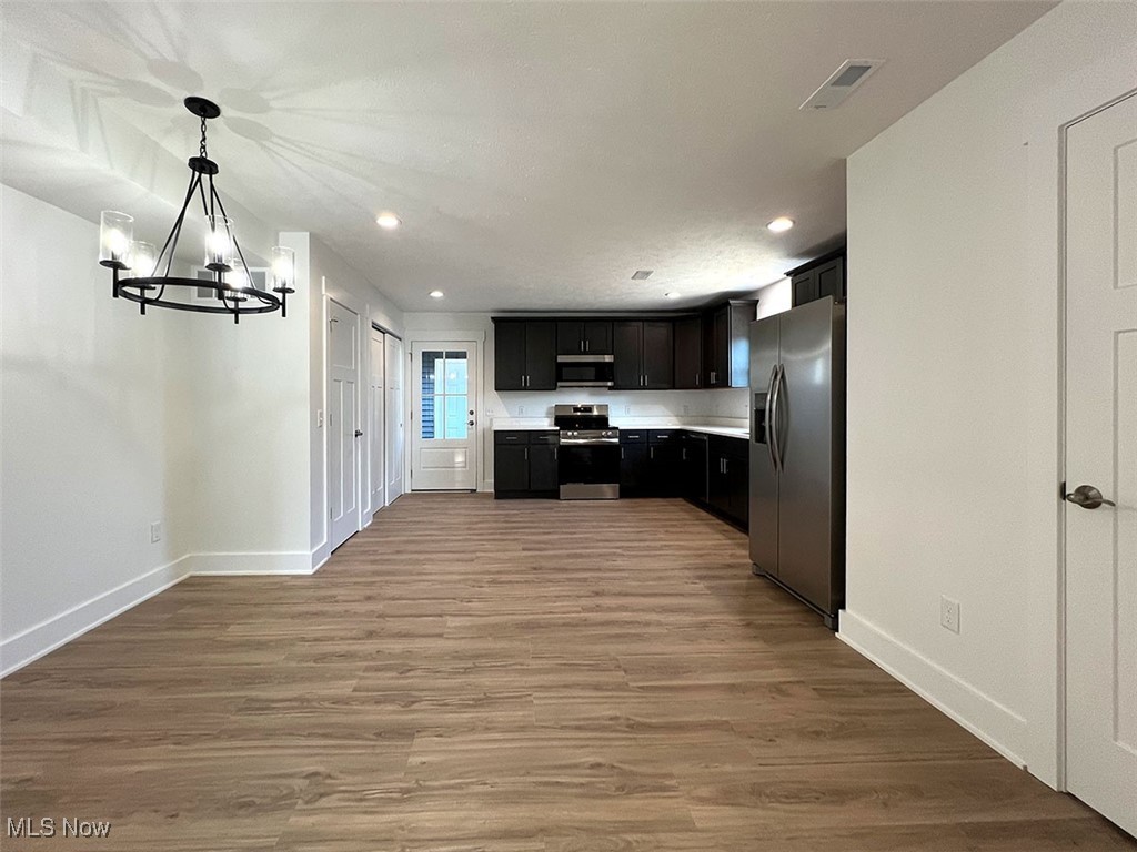 3641 Menlo Road Cleveland, OH 44120 - Photo 5 of 26 Open concept kitchen with shaker cabinets, appliances with stainless steel finishes, quartz countertops, recessed lighting, and light wood-style floors