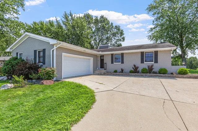 a front view of house with yard and trees around