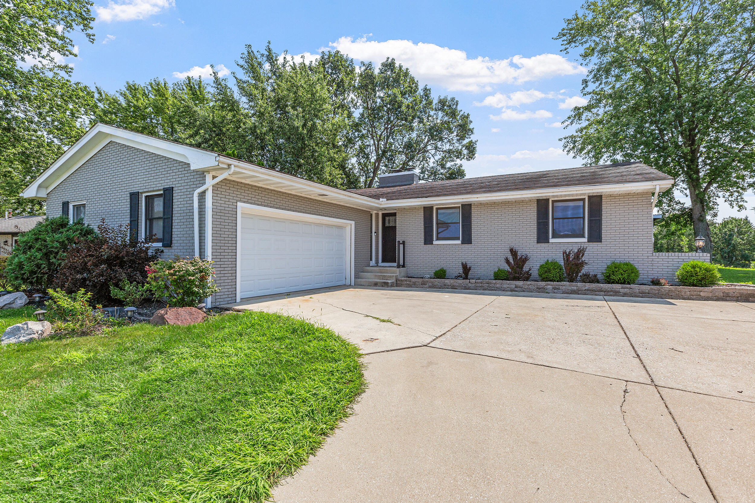 a front view of house with yard and trees around