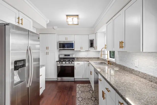 a kitchen with stainless steel appliances granite countertop a refrigerator stove and sink