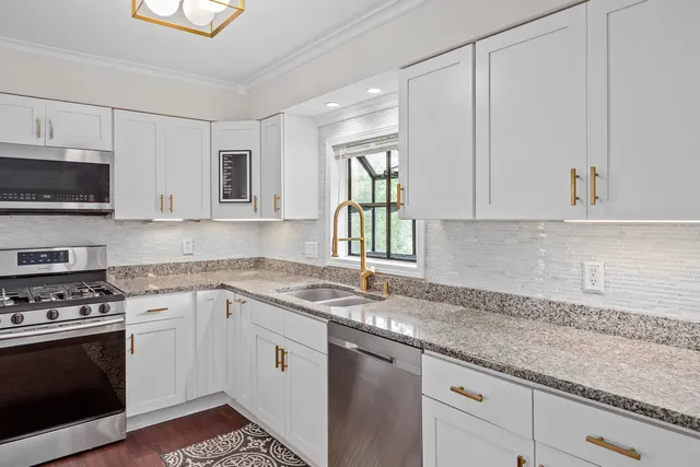 a kitchen with granite countertop a sink a stove and microwave