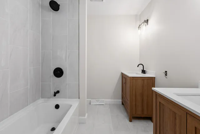 a bathroom with a tub sink and shower