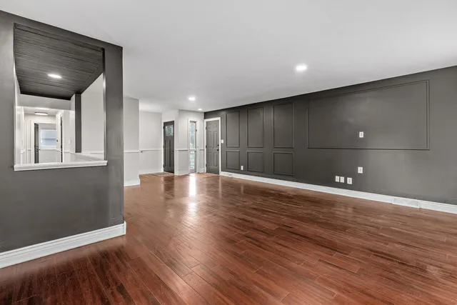 a view of an empty room with wooden floor