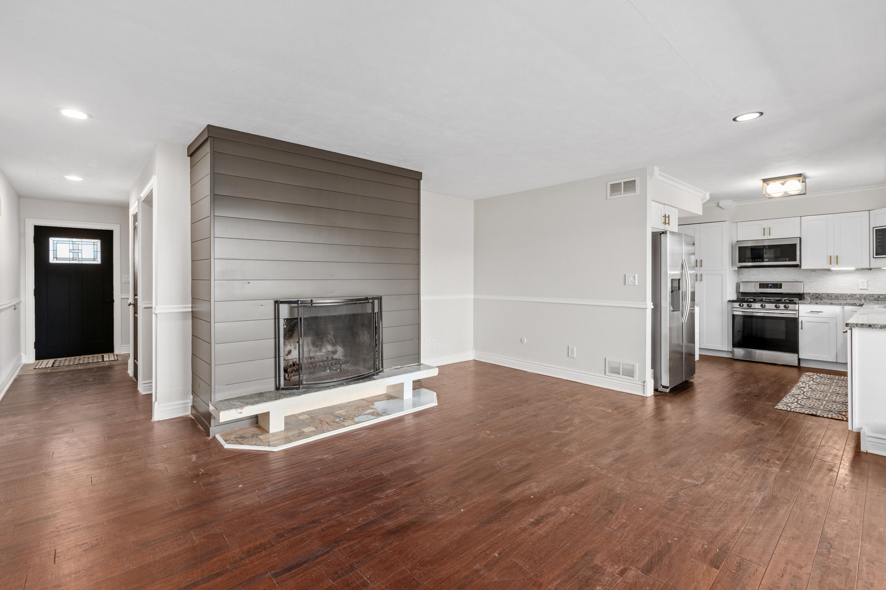 4152 Oakmont Court Crown Point, IN 46307 - Photo 10 of 34 an empty room with wooden floor fire place and kitchen view