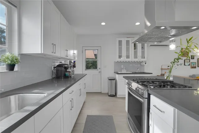 a kitchen with stainless steel appliances granite countertop a sink stove and cabinets