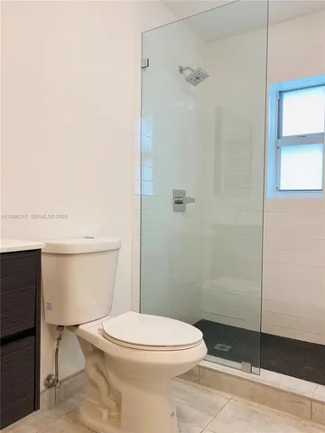 a white toilet sitting next to a bathroom sink and vanity