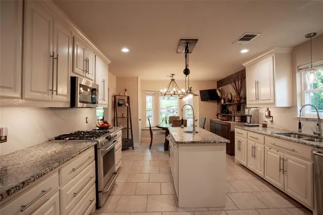 a kitchen with stainless steel appliances kitchen island granite countertop a sink and cabinets