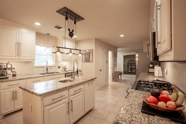 a kitchen with stainless steel appliances a sink stove and cabinets