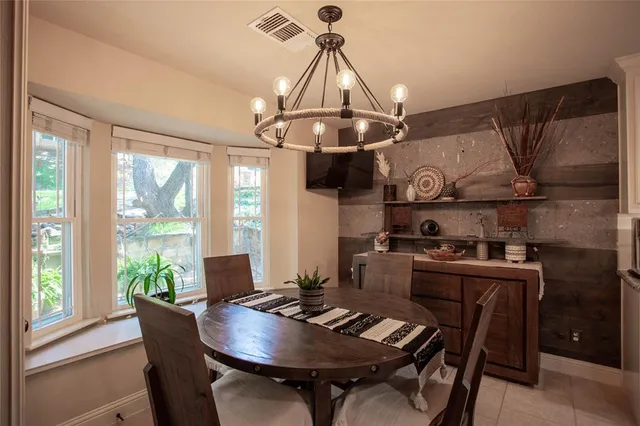 a dining room with wooden floor a chandelier a wooden table and chairs