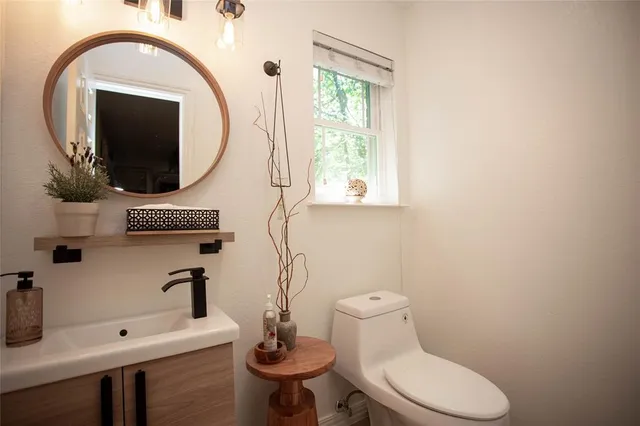a bathroom with a toilet sink and mirror