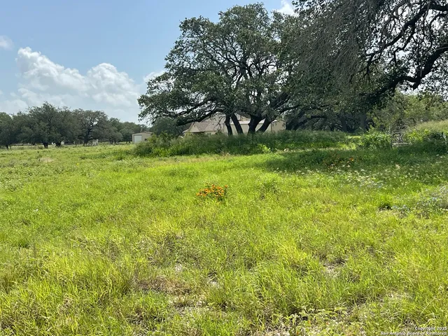 a view of a green field with wooden fence