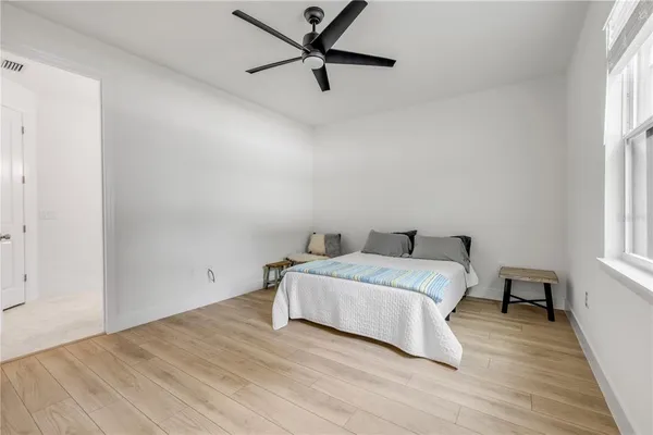 a spacious bedroom with a bed and a window