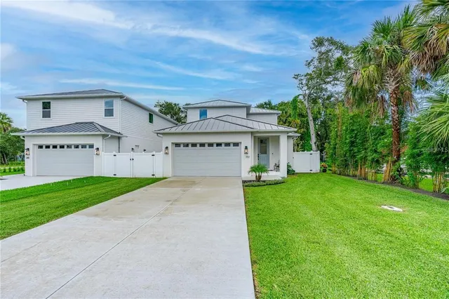 a view of a house with a yard and a large tree
