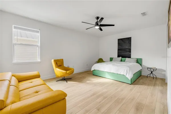 a bedroom with a bed a couch and a window